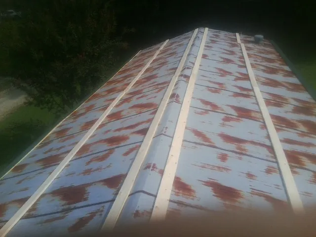 Rusted metal roof panels with new wood purlins before replacement — Storm Damage Roof Repair in Trinity by Roofing Brothers